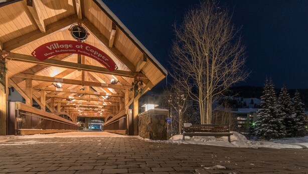 A wooden building with a sign reading "Village at Copper." - Beautiful one bedroom condo steps from the American Flyer Lift. (Copper Mountain)