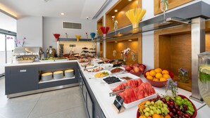 A buffet with various food items and a glass display case with fruits. - Graziella Gold Hotel (Istanbul)