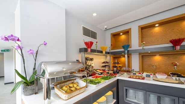 Un espace buffet proposant une variété de plats, un coin barbecue et des éléments décoratifs tels que des orchidées et des fleurs.