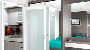 Un dormitorio moderno con cama, baño y kitchenette.