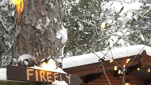 Eine Holzhütte mit einem Schild, auf dem "FIREFLY" steht, und einer Bank davor.