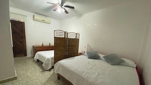 A bedroom with two single beds, a ceiling fan, and a wooden wardrobe. - Family bungalow near the sea (Centro)