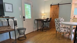 A dining area with a table and chairs, a lamp, and a door with a window. - Charming Orchard Cottage…Pet Friendly!! (Chico)
