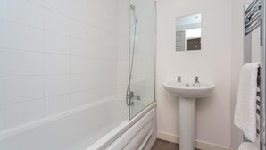 A bathroom with a glass-enclosed shower, a pedestal sink, and a mirror above the sink. - Cherry Property - Blueberry Suite (Blackpool)