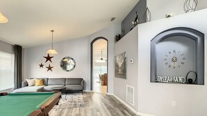 A modern living room with a pool table, grey sofa, and decorative wall art. - MAGIC 5* LAKE VIEW VILLA HEATED POOL&HOT SPA, near DISNEY, 10 Guests (Kissimmee)