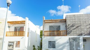 Un bâtiment moderne aux murs blancs et doté de balcons, sur lequel on peut voir une enseigne portant le numéro 29.