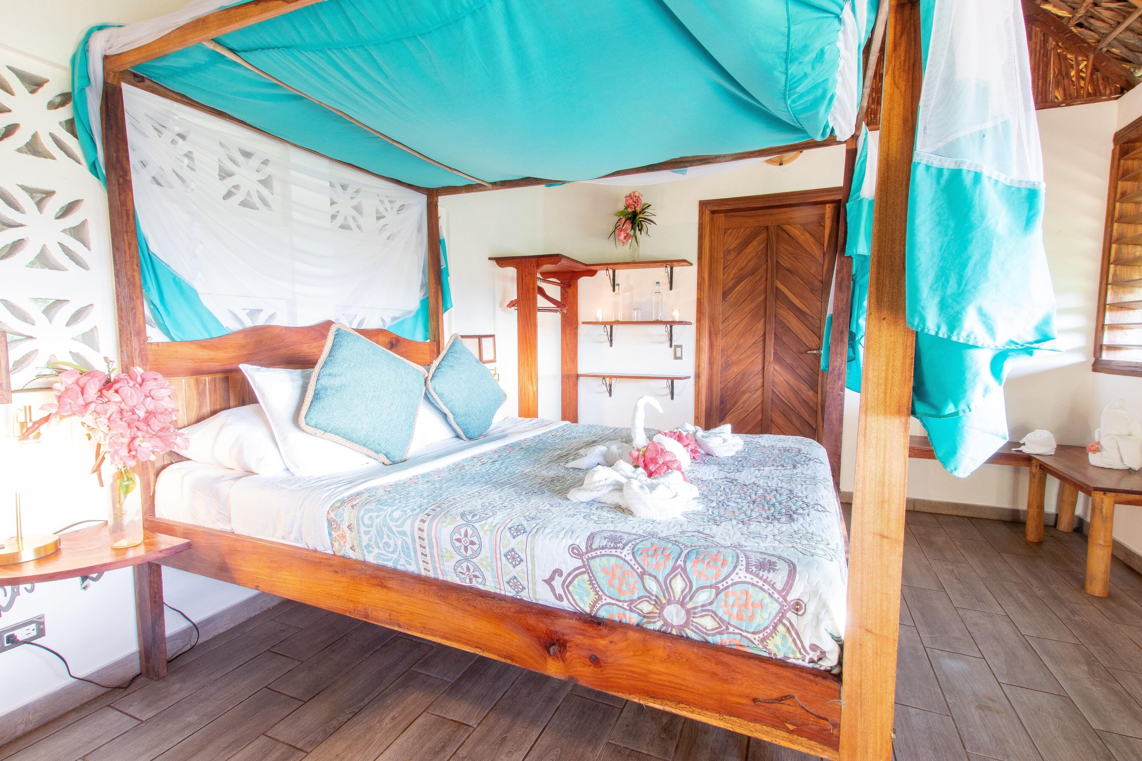 Una cama con dosel, un edredón estampado, y un cabecero de madera.