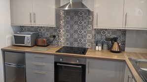 Una cocina moderna con electrodomésticos de acero inoxidable, un salpicadero con diseño y encimeras de madera.