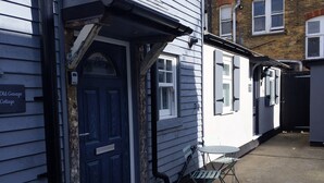 Una puerta azul con un letrero que dice 'Old Garage Cottage'.