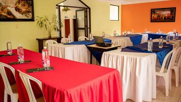 A conference room with tables set for meetings, equipped with laptops and water bottles.