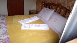 Una cama con una colcha amarilla, un cabecero de madera y una almohada blanca con texto.