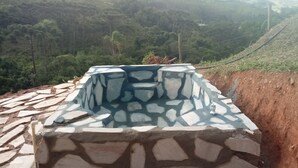 Una escalera de piedra que sube por una ladera, con vista a un valle boscoso y montañas distantes.