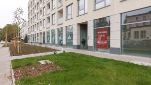 Un bâtiment moderne doté de grandes fenêtres et d’une pelouse verdoyante.