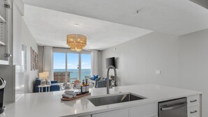 A modern kitchen with a large island, stainless steel appliances, and a view to the outside. - Full Ocean Views, Steps to the Sand, Beach Chairs, Heated Pool/Hot Tub, Sleeps 8 (Miramar Beach)