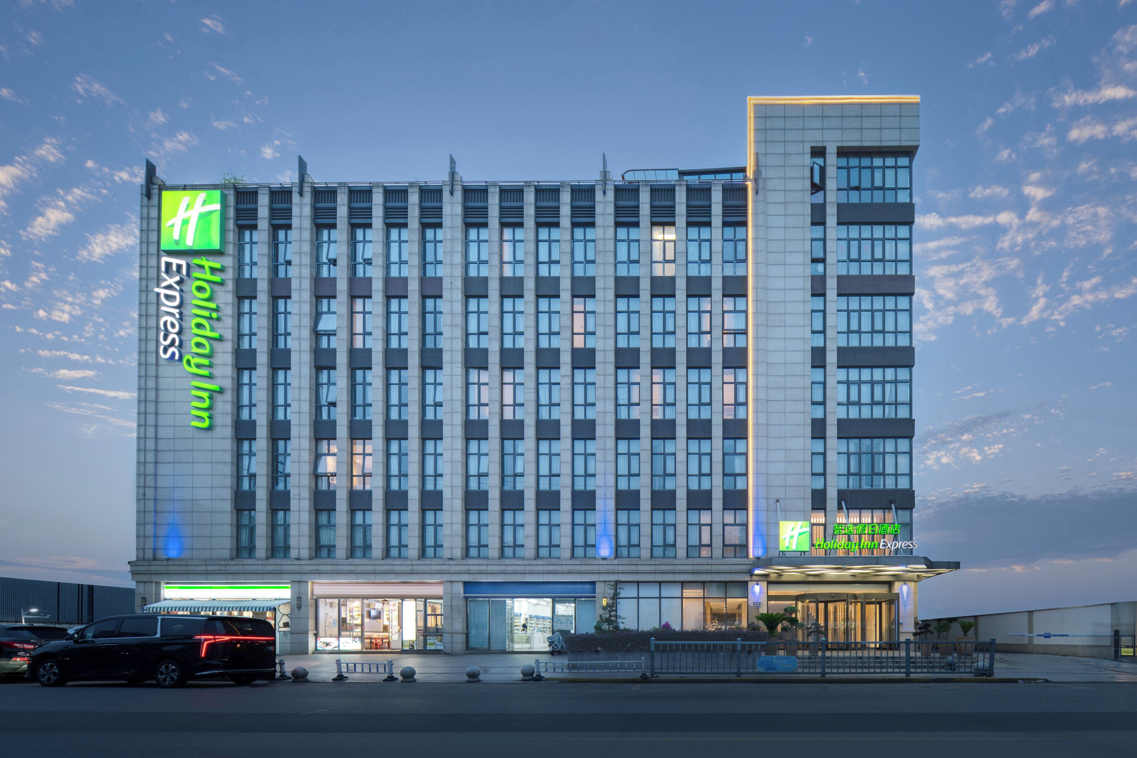 Un hôtel Holiday Inn Express doté d’une façade moderne, de plusieurs étages et d’une entrée imposante.