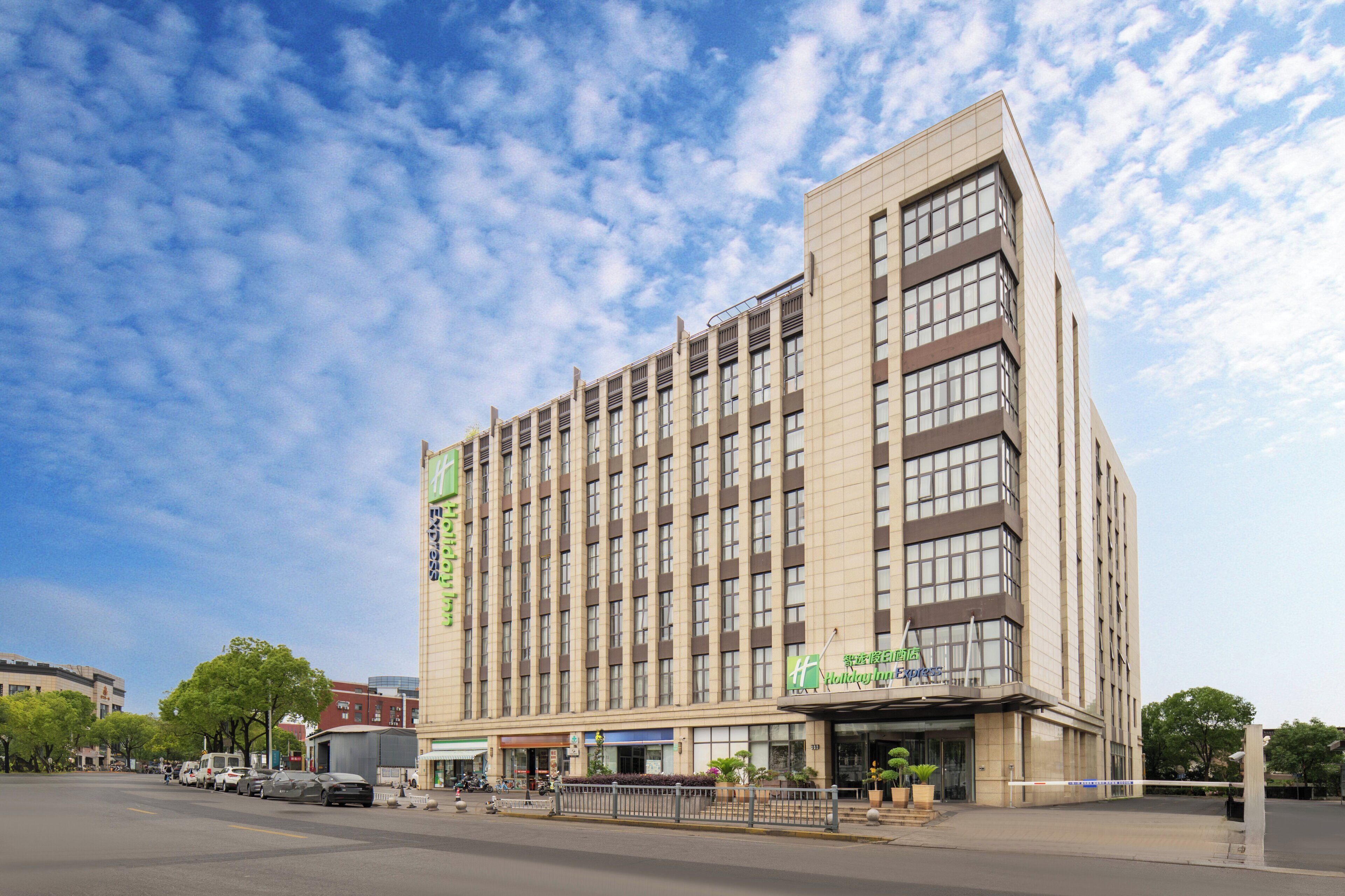 A multi-story hotel with a modern design, featuring a prominent entrance and signage for the Holiday Inn Express.
