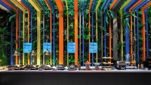 A buffet area with a variety of dishes and a colorful vertical garden backdrop. - Holiday Inn Express Shanghai Hongqiao North by IHG (Shanghai)