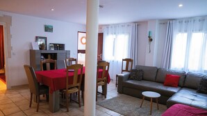 A living room with a dining area, a sofa, and a small table.