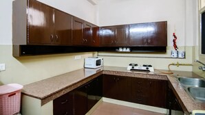Una cocina con armarios marrones, un microondas y un lavamanos.
