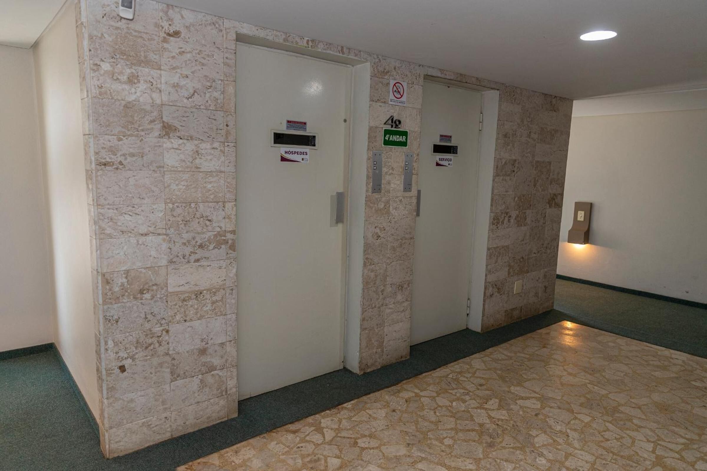 A hallway with two doors labeled "HOSPEDES" and "SERVIDO".