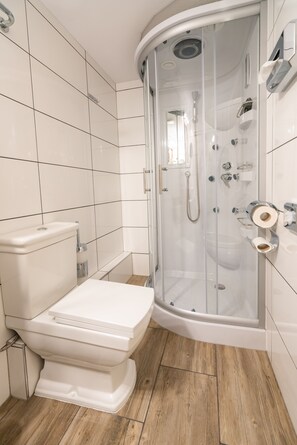 Habitación individual | Baño | Ducha, secador de pelo, zapatillas y toallas