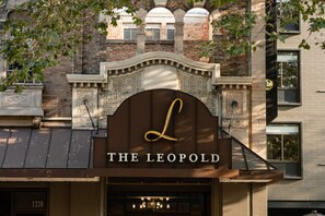 Un edificio con un cartello che riporta "THE LEOPOLD" e un'imponente architettura sopra l'ingresso.
