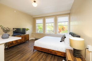 Une chambre à coucher avec un lit, une télévision, une table de chevet et une fenêtre.