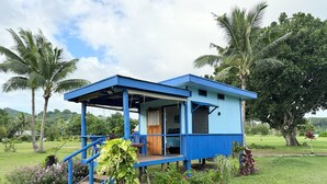 Ein kleines, eingeschossiges Gebäude mit blauer Fassade und einer überdachten Veranda.