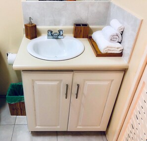A bathroom with a white sink, wooden soap holder, and a towel rack. - Waterloo Executive Guest Apartment (Kingston)
