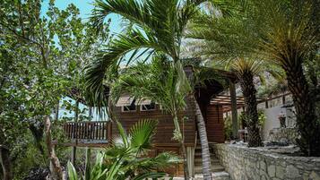 A wooden cabin with a stone wall and a wooden deck.