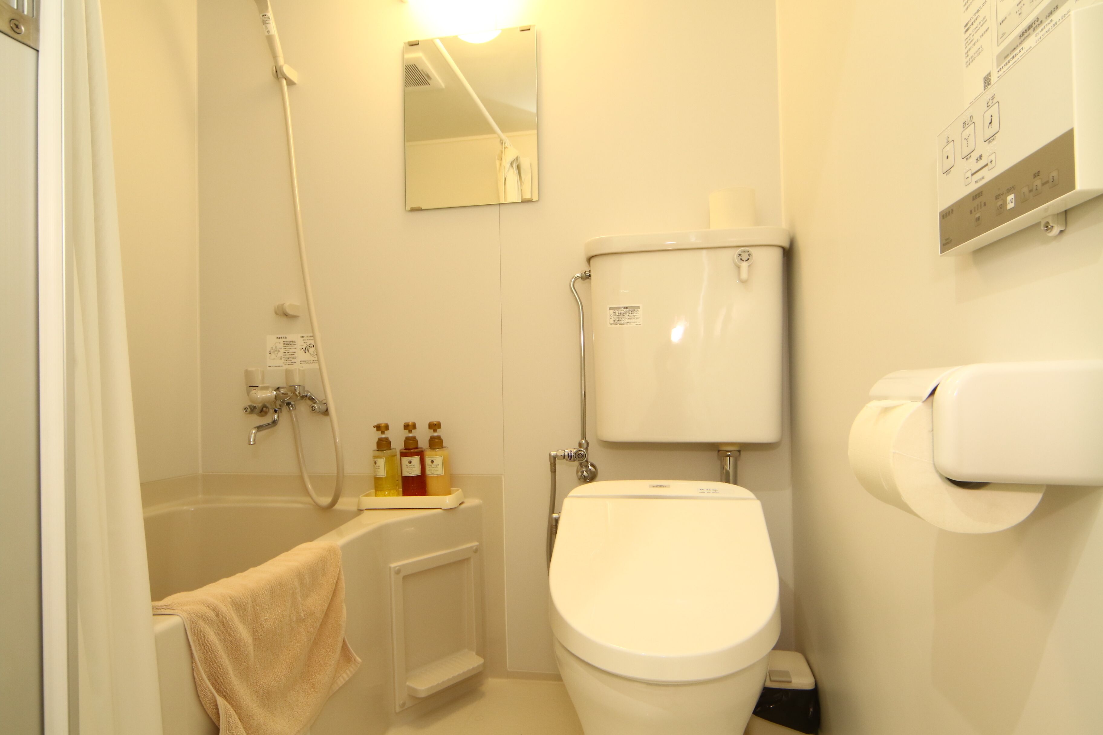 A small, clean bathroom with a toilet, a sink, and a shower.