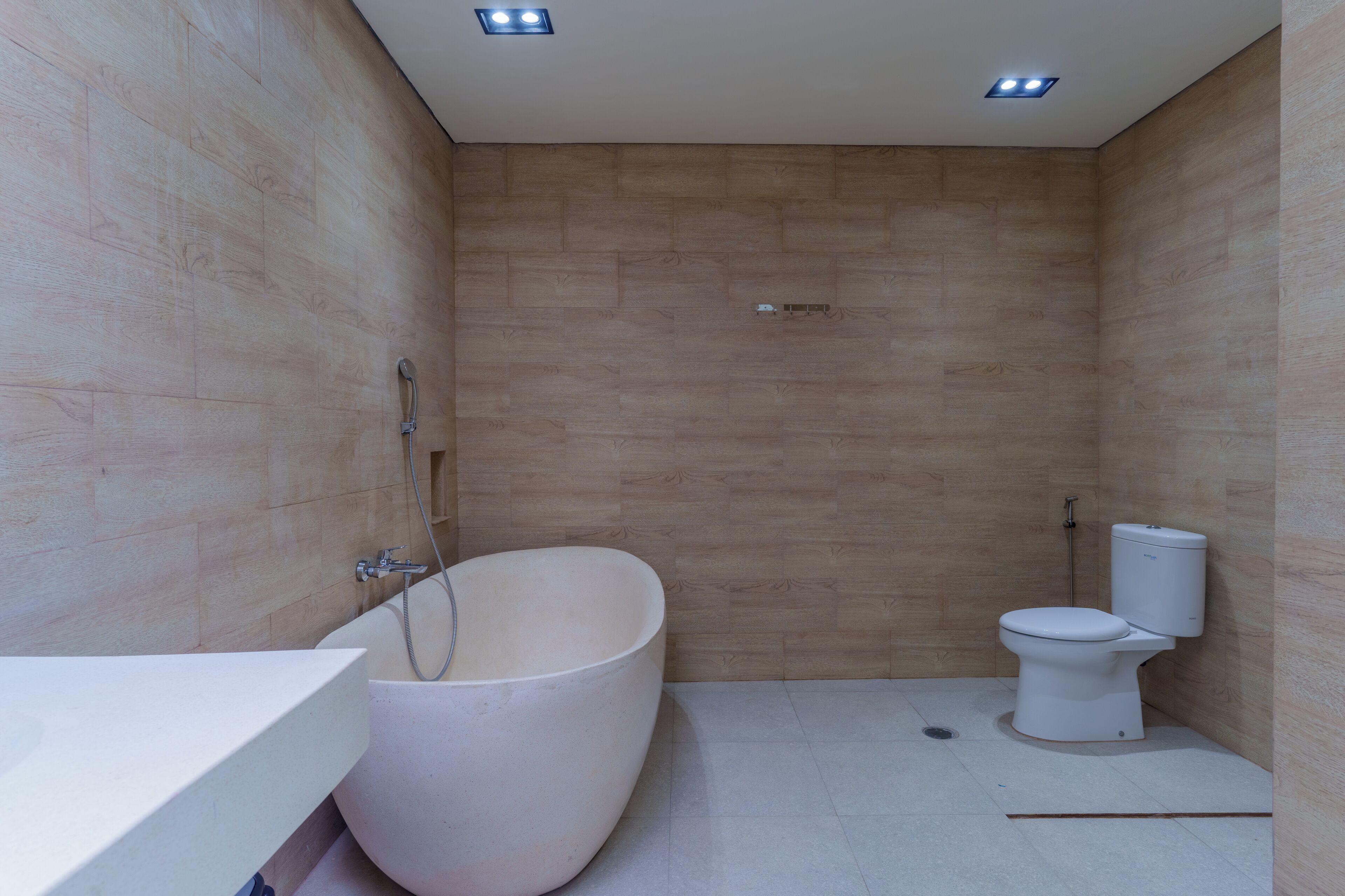A modern bathroom with a freestanding bathtub, a toilet, and a sink.