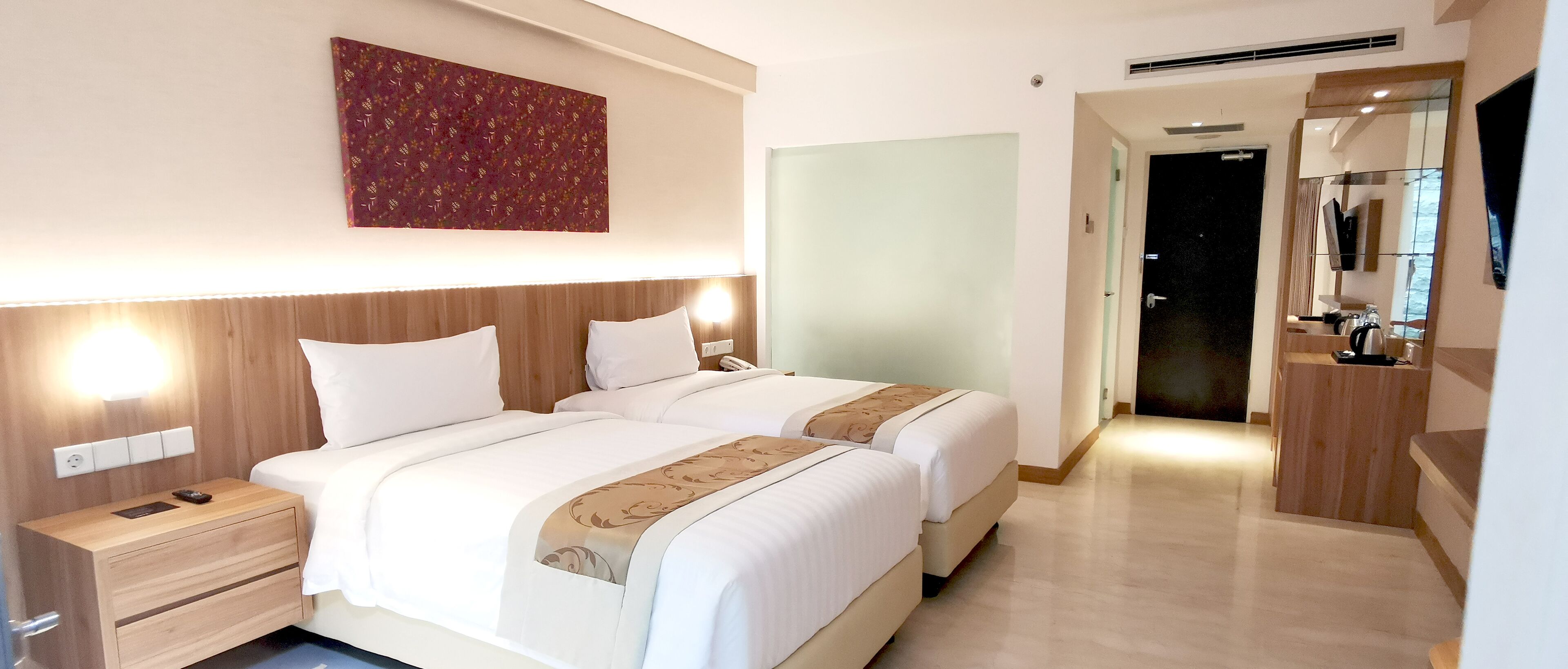Habitación de hotel con dos camas, una mesita de noche, una obra de arte en la pared y un espejo.