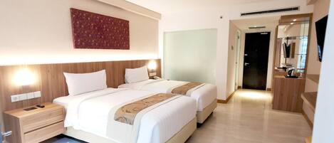 Habitación de hotel con dos camas, una mesita de noche, una obra de arte en la pared y un espejo.
