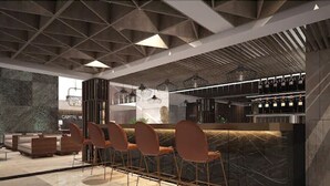 A modern bar area with a high ceiling, geometric ceiling design, and a bar counter with stools. - The Capital Hotel and Resort Seminyak (Keroboken Kelod)