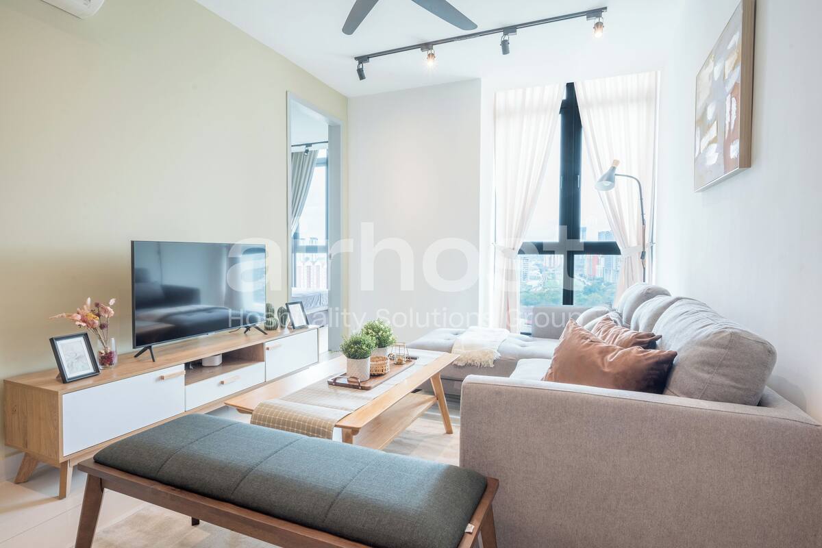 A modern living room with a flat-screen TV, a wooden coffee table, a grey sofa, and a bench.