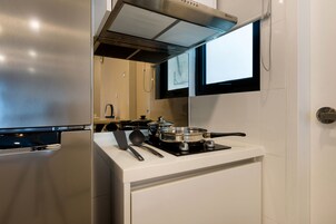 A modern kitchen with a stainless steel refrigerator, a built-in stove, and a window above the sink.