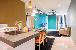 Une cuisine moderne dotée d’un îlot central, d’un coin repas avec des chaises, d’un canapé et d’un ventilateur de plafond.