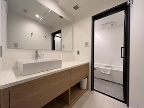 Een aparte badkuip en douche, een diep bad, gratis toiletartikelen