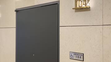Una puerta con un cartel que indica el número de habitación 104 y un símbolo de accesibilidad para sillas de ruedas.