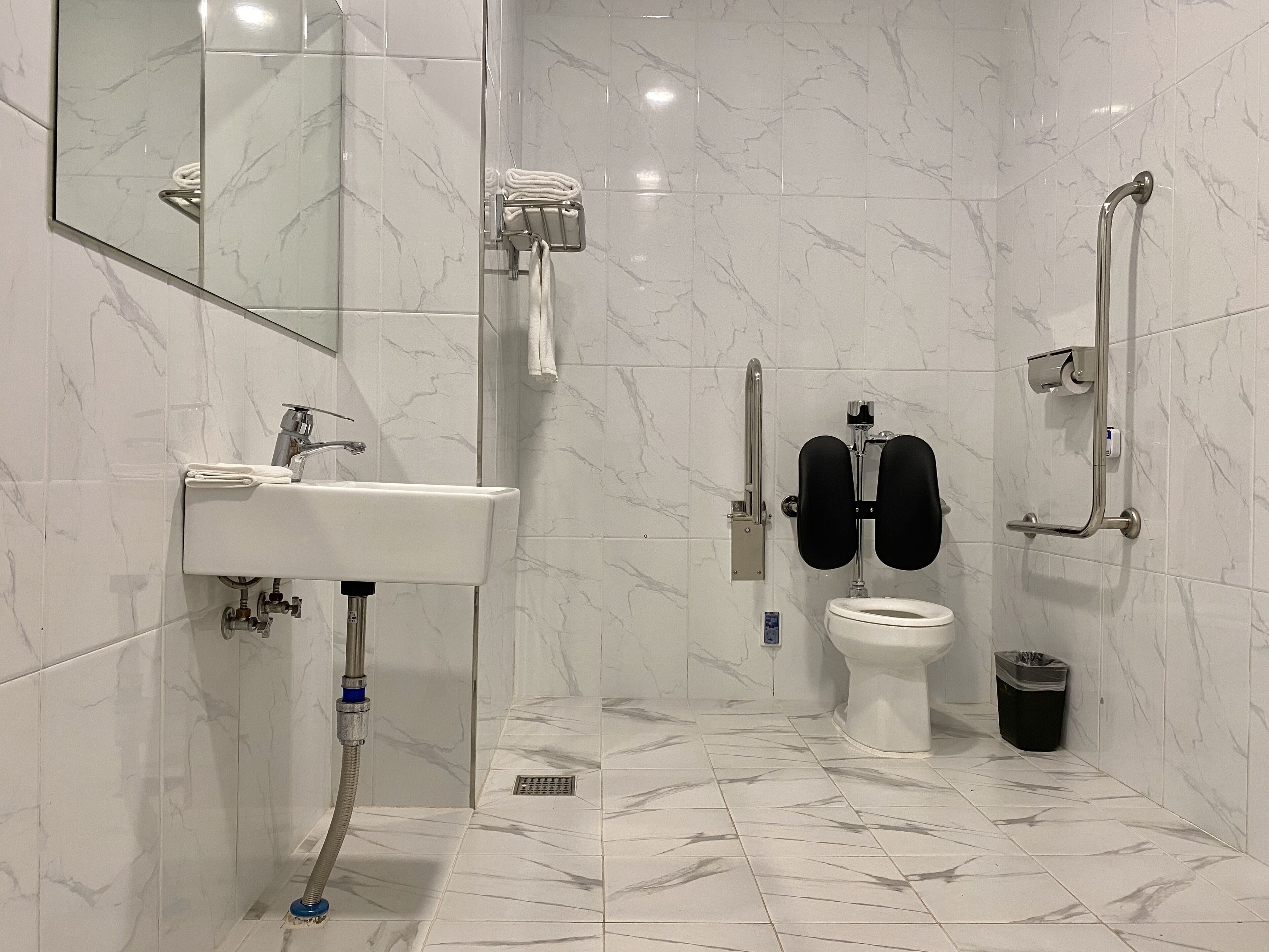 Un baño moderno con lavamanos, inodoro y zona de ducha.