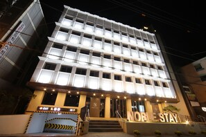 A multi-story hotel with a modern facade, illuminated signage, and a prominent entrance with steps. - Noble Stay (Daegu)