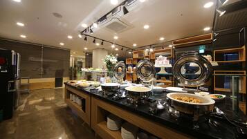 A buffet setup with multiple serving stations, a variety of dishes, and a modern interior design.