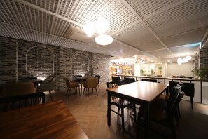 A restaurant with brick walls, wooden tables, and chairs. - Noble Stay (Daegu)