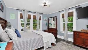 A bedroom with a bed, dresser, mirror, and large windows. - Lake Norman Shabby Chic bungalow in Cornelius close to Davidson (Cornelius)