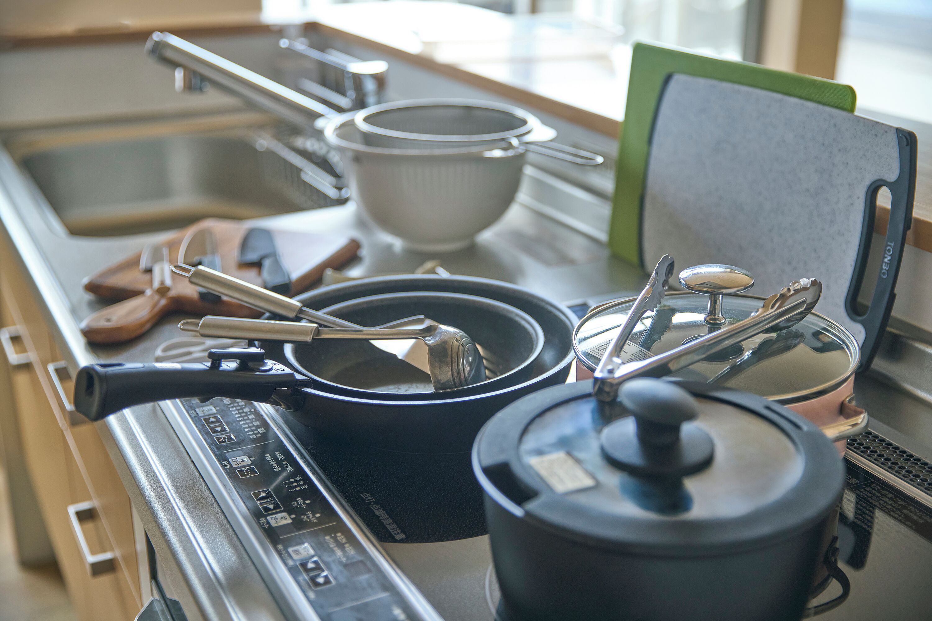 A kitchen with a stove, pots, and utensils.
