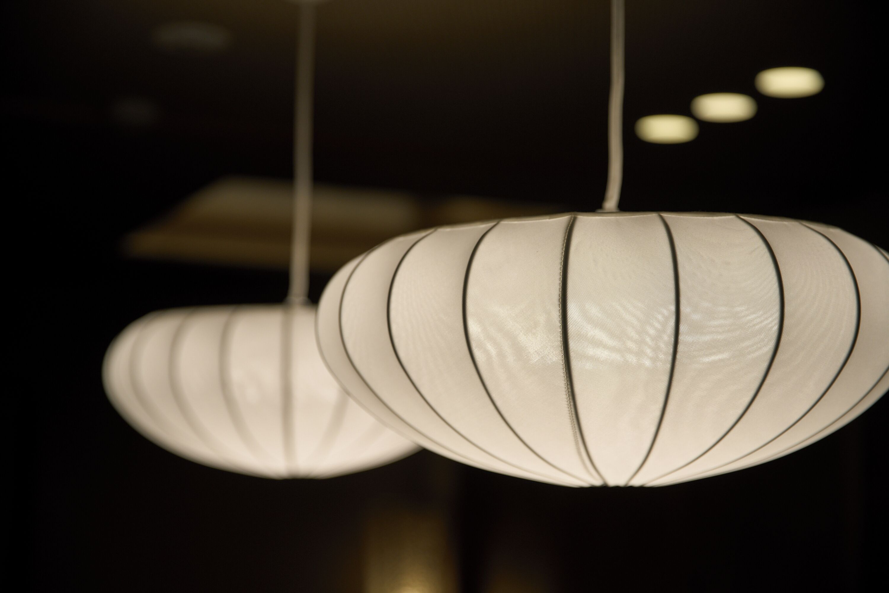 A close-up of a hanging light fixture with a ribbed design.