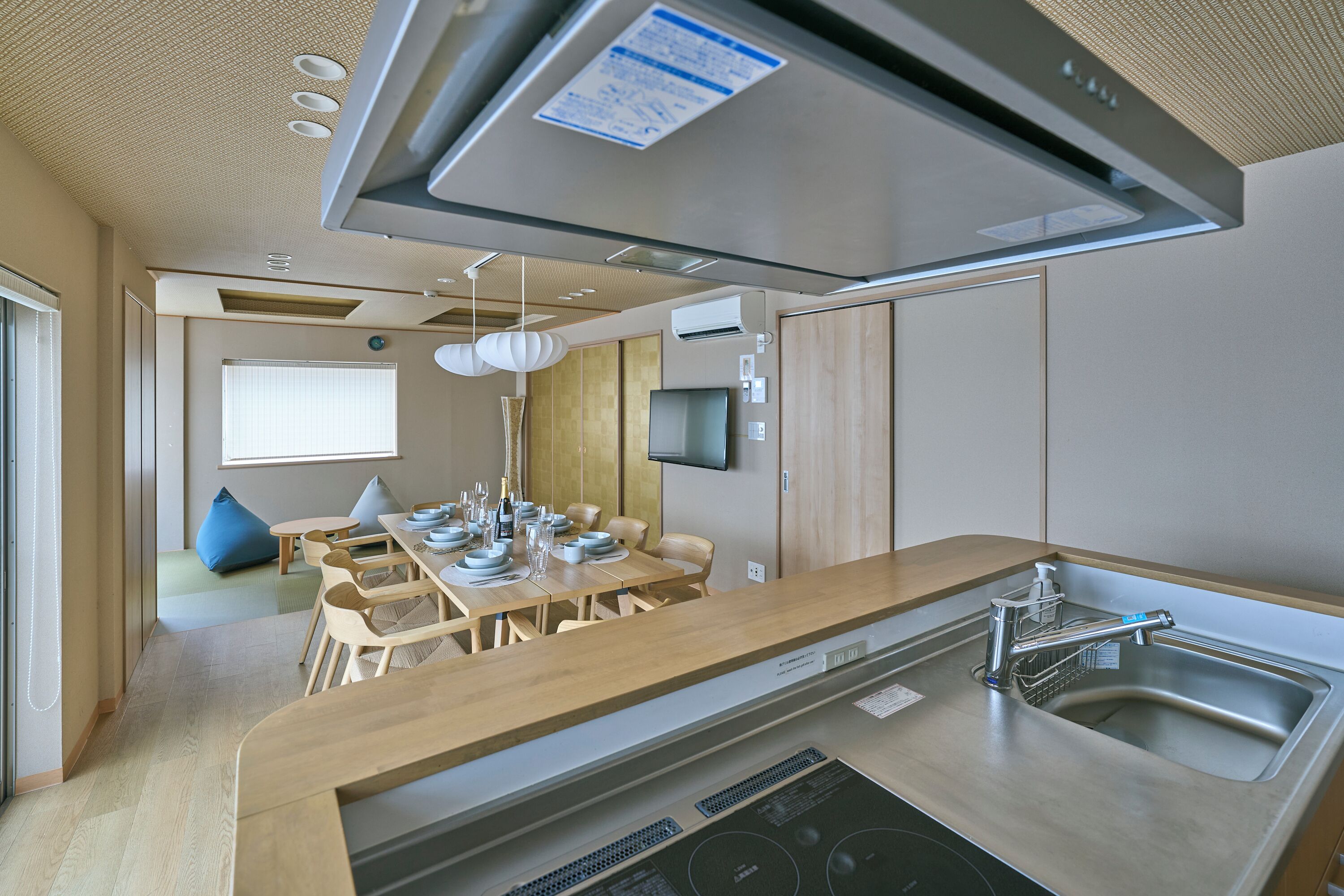 A modern kitchen with a central island, built-in oven, and a stainless steel sink.