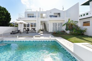 A modern two-story house with a swimming pool, outdoor seating, and a well-maintained garden. - Route 6 Inn (Yomitan)