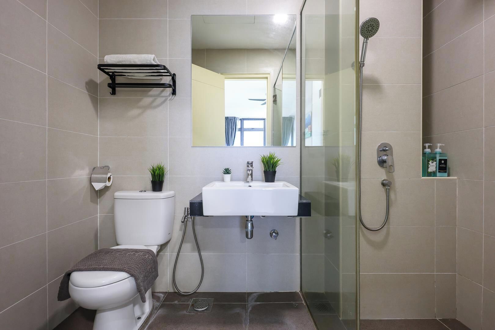 A modern bathroom with a toilet, sink, and shower.